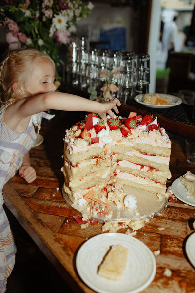 child stealing from the cut wedding cake