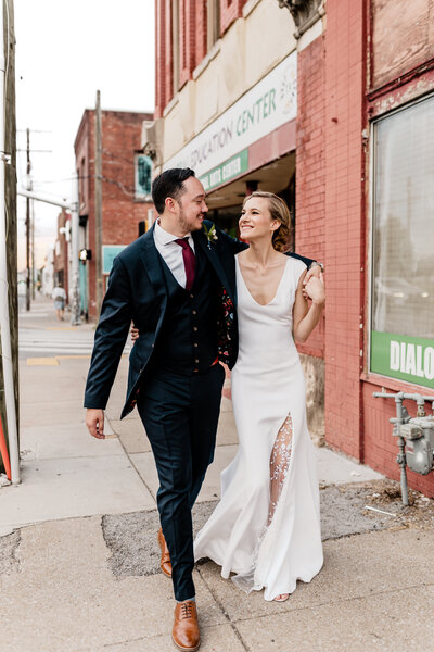 bride and groom walking on the sidewalk