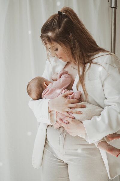 Een vader houdt zijn baby liefdevol vast, met een warme glimlach op zijn gezicht.