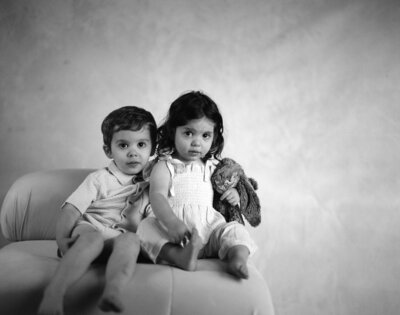 two siblings looking at camera in photo studio