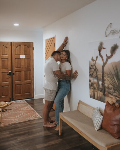 A couple sharing intimate, candid moments during an in-home photoshoot in Los Angeles, capturing their love in a cozy, natural setting.