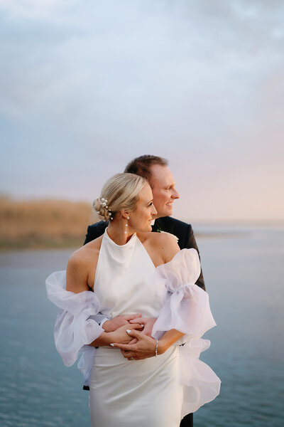 Romantic sunset portrait of bride and groom at Cape May wedding on the water