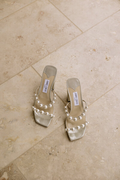 Brides Jimmy Choo wedding shoes sitting on tile floor.