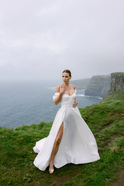 Bride posing on the top of the cliffs of Moher in Ireland