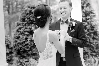 A bride and groom playfully wnader the gardens of Gramercy Mansion emanating joy
