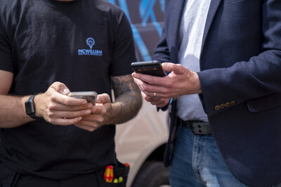 two people looking at their phones in dark colours
