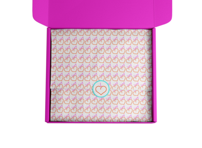 Hot pink cardboard box with Lovey pattern tissue paper and lovey peach round stick in center