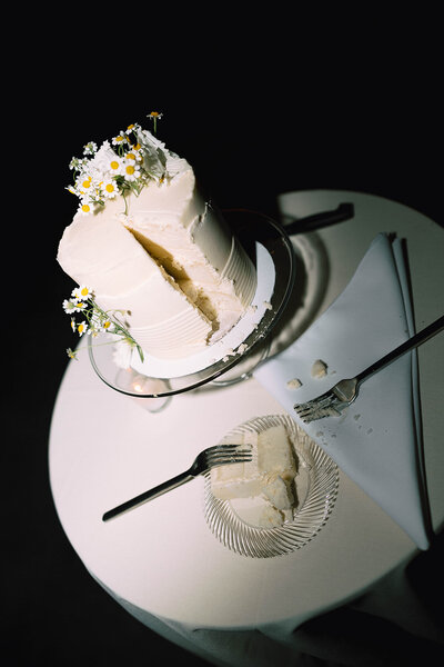 White wedding cake with a slice served on a plate