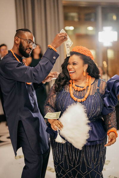 Nigerian bride and groom doing traditional money spray at wedding in Chicago