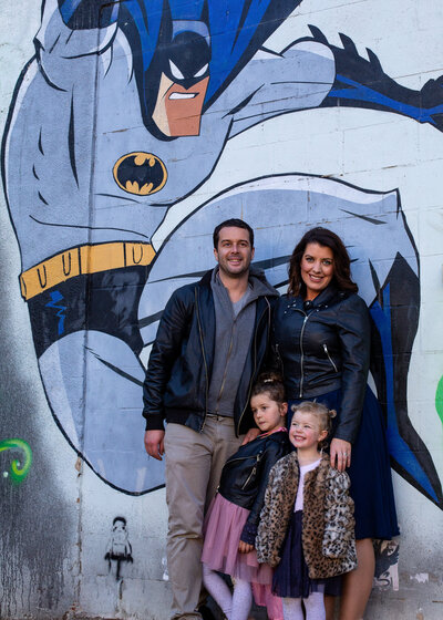 family in front of batman street art