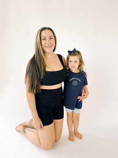 woman kneeling in black beyond yoga biker shorts and square neck bra