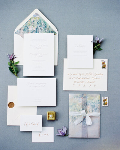 Invitation suite flat lay on blue backdrop