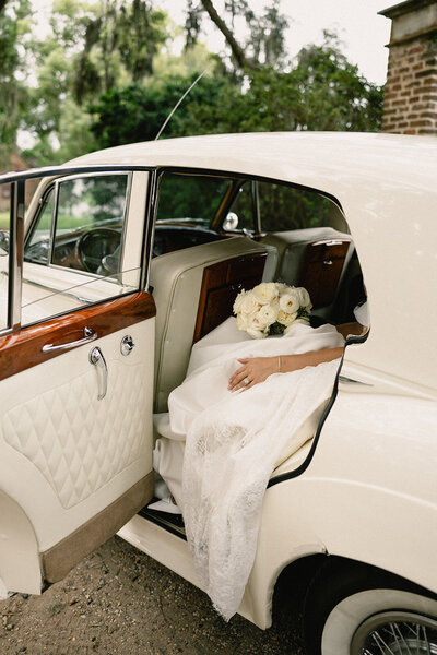 Bride holding bouquet with soft natural light in a Charleston park.