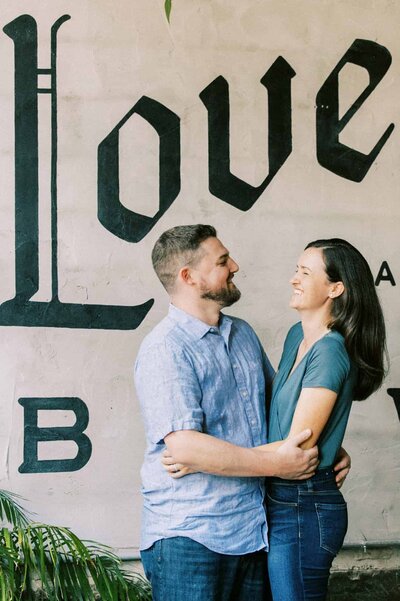 Engagement portrait with brewery logo in background