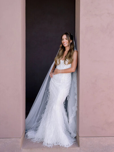 bride wearing strapless white  lace wedding dress with long train