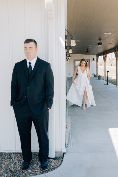 A Bride walks toward her groom at a first look . Photo by Anna Brace, a wedding photographer in lincoln ne.