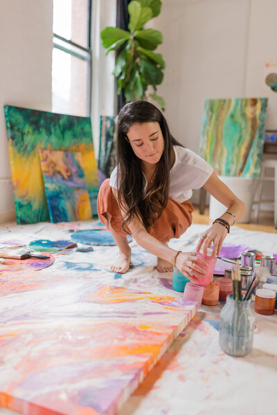 Courtney Claire Beglin mixes paint colors in her art studio