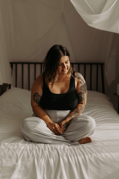 B&W Photo of girl with tattoos next to the window