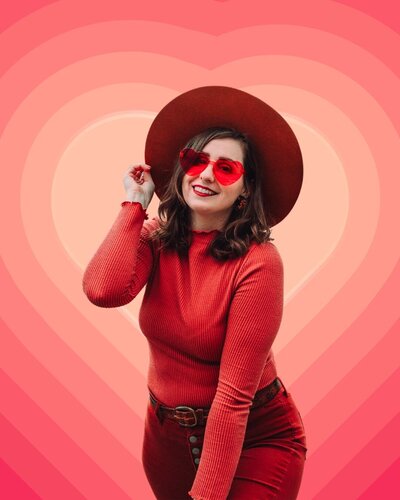 Portrait of Mewphotovideo founder Morgan standing in vibrant and bold monochrome red heart backdrop – personal brand photo for creative entrepreneur