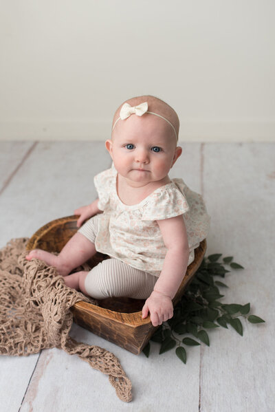 Baby girl wrapped in blush on white bed