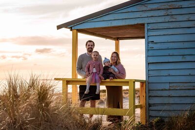 Family of four taken at dusk at an iconic Melbourne beach box
