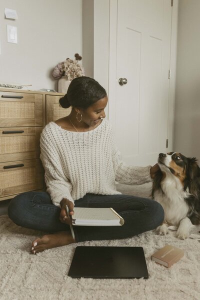 Chantia Sturman and her dog sitting on the floor