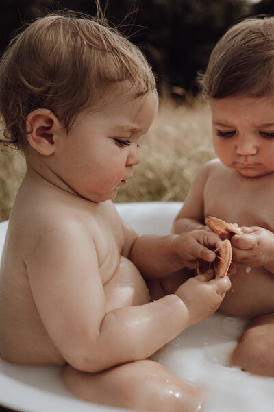 Kindjes spelen in melkbad tijdens cakesmash fotoshoot