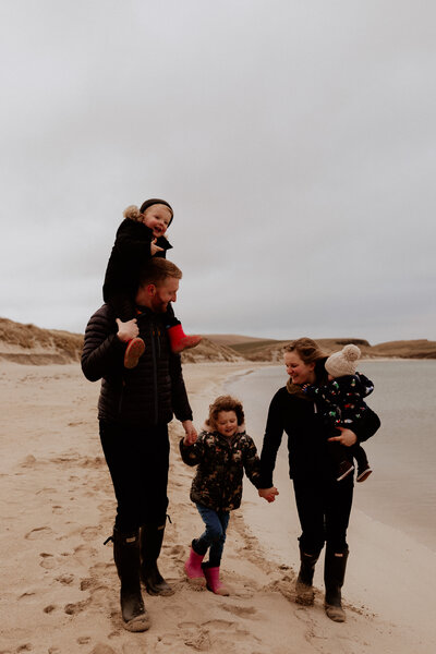 family of five walking on the beach