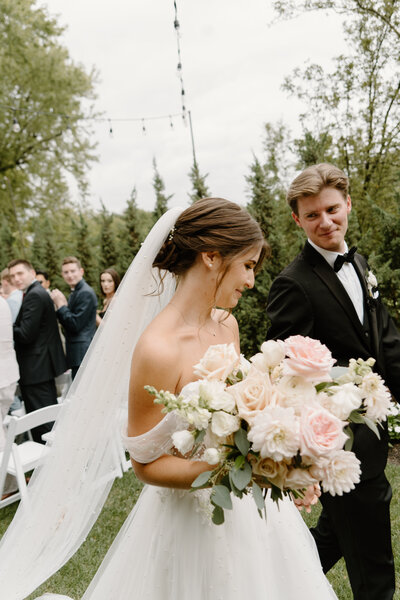 Sophisticated bridal bouquet featuring white lilies, roses, and lush greenery, designed by Leigh Florist for an elegant wedding.