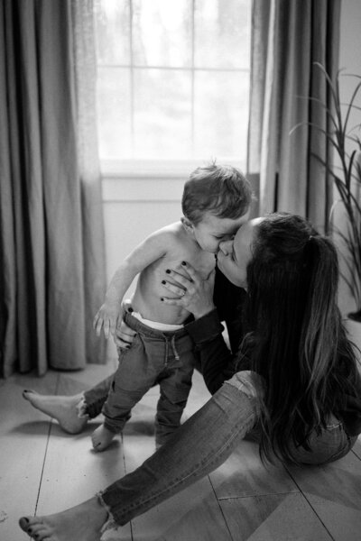 mom kisses her little boy in sweet black and white photo