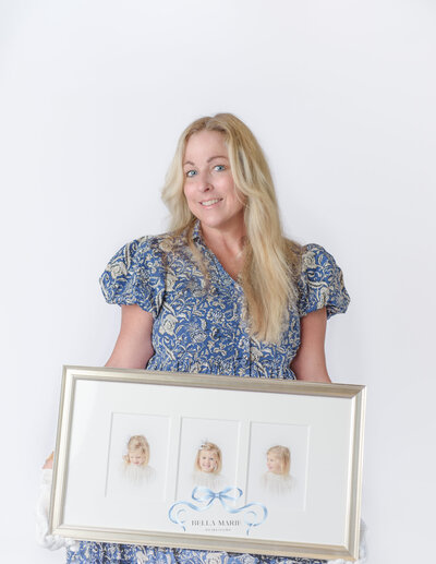 Blonde hair and blue-eyed female wearing a blue printed dress and holding a three-panel heirloom portrait of a little girl