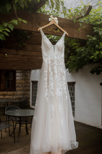 Hanging wedding dress in the bride's dressing room at a wedding in MN.
