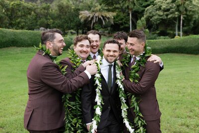 A newlywed laughing with their wedding party around them 