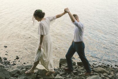 bride leads groom along the shore during their Newfoundland elopement