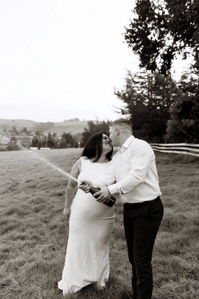 couple holding each other in front of a barn