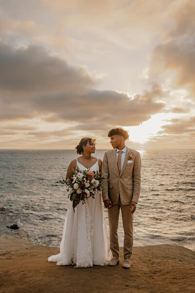 bride and groom in front of ocean