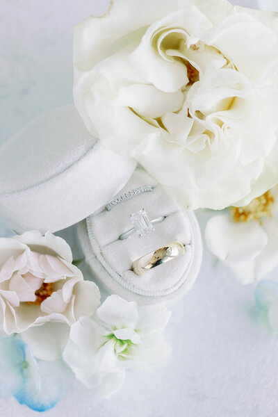 Elegant flat lay of wedding ring in a ring box with flowers photographed by Kortney Boyett, DFW wedding photographer