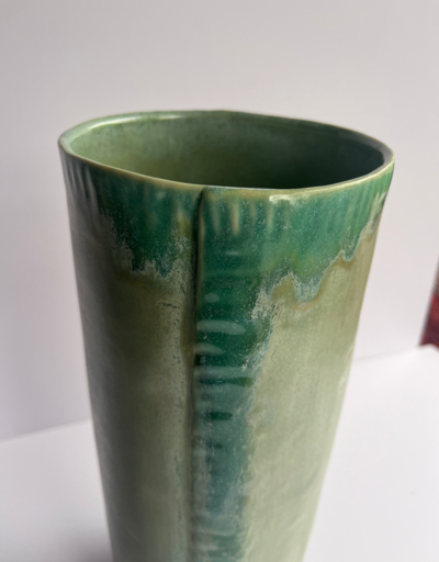 Four green textured serving bowls are displayed nested inside one another, the smallest one has a hole on the side meant for using tas a fingerhold
