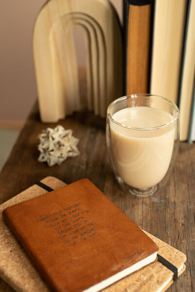 Werken aan je bedrijf. Tafel met twee notitieboeken, een mok thee  en boeken op de achtergrond.