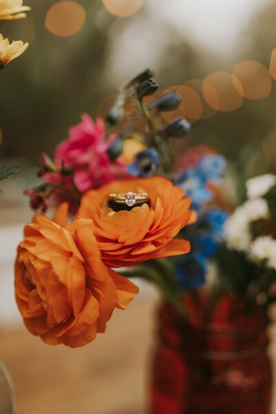 close up of wedding rings on wedding flowers