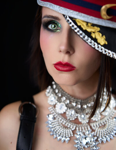 Woman in magazine-styled portrait with a captains hat dark hair and red lips