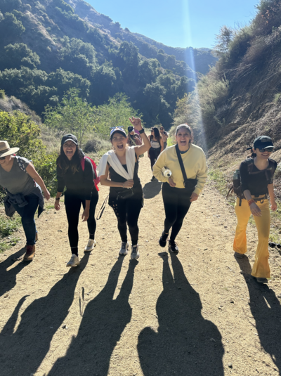 Latina creatives hiking in nature during a Latinas Acting Up mountaintop meditation event to foster connection and reflection.