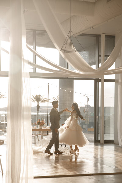 couple holds hands and laugh during engagement session in san diego