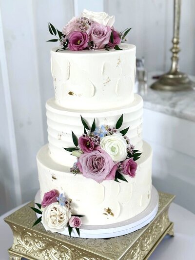 Elegant wedding cake from Icing on the Cake Bakery, beautifully decorated with intricate icing details, perfect for a special celebration.