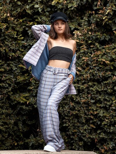 girl posing in a pants suite gray and plaid with tube top on and jacket