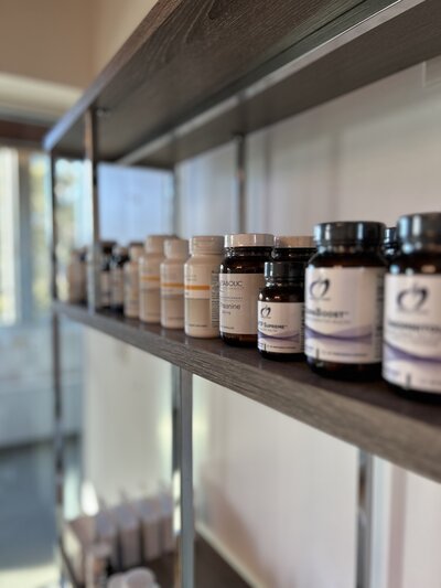 A shelf displaying various jars of vitamins and health products organized neatly.