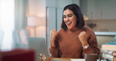 Female PA student smiling while studying for the PANRE exam on her laptop