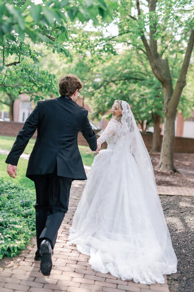 Couple running away from camera during wedding portraits 