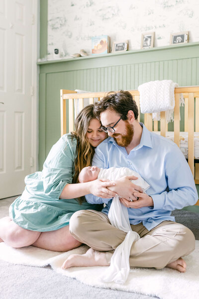 Heartwarming scene of Elyse Stokes with her family cuddling in the nursery, capturing a precious moment