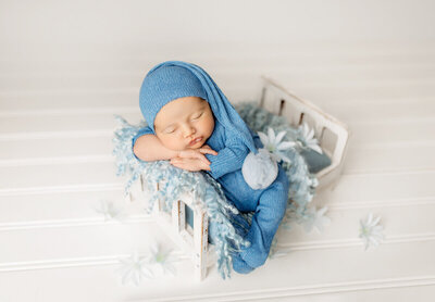 Airy newborn photograph with gentle highlights, minimal styling, and soft neutrals for a modern fine-art look.